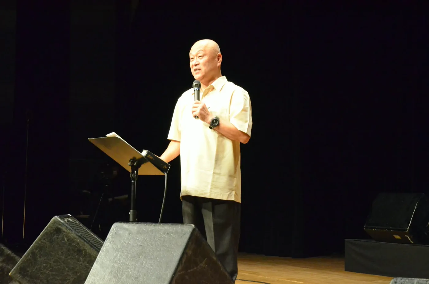 Pastor Jun Takimoto predicando sobre un escenario